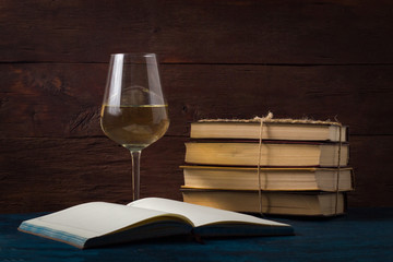 Glass with White Wine, Open Book on the Blue Table