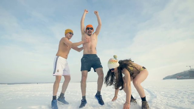A man gets rubbed with snow by his laughing friends. 4K.