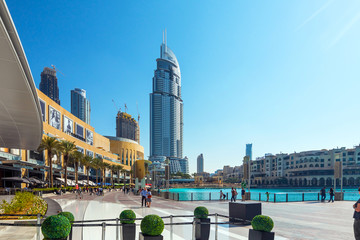 Downtown Dubai skyline, view from the Dubai fountain. Modern city cityscape with skyscrapers, sidewalk with perspective in sunny day.