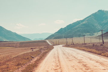 Rural road in Altai mountains. Creative vintage toning