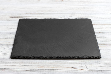 Slate board over old wooden background with copy space