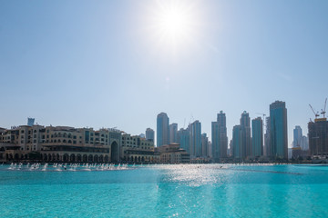 Downtown Dubai skyline, view from the Dubai fountain. Modern city cityscape with skyscrapers, sidewalk with perspective in sunny day.