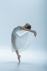 beautiful ballerina dancing in studio, isolated on white