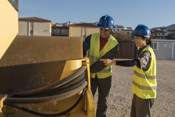 Fototapeta premium Couple of worker controling tire preassure in heavy machine vehicle