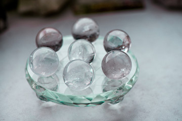 Macro shot of transparent crystal balls with colorful ornaments and sun reflections in it, on turquoise glass pad. Fortune telling. Love, money, luck, success.