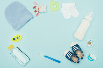 top view of baby clothes, accessories and milk isolated on blue