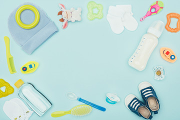 Fototapeta na wymiar top view of baby clothes, equipment and milk isolated on blue