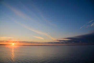 Golden, colorful, abstract sea sunrise view at horizon, vibrant sky landscape and small waves in the water