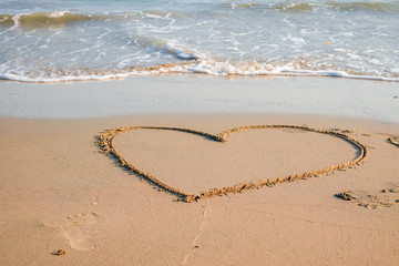 Heart drawn on the sand of a sea beach