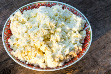Homemade cottage cheese on old wooden table