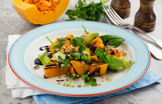 Roasted pumpkin salad with spinach, avocado, seeds and balsamic sauce