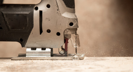 Master cuts wood with a jig saw