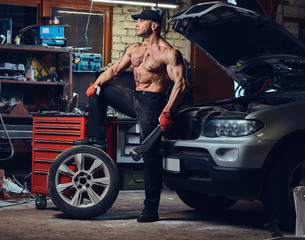 Obraz na płótnie Canvas A man repairing wheel of a car.