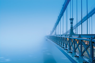 Pont à chaînes Szechenyi dans un épais brouillard bleu sans côte visible. Budapest