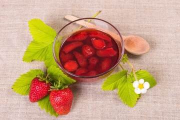 Fresh red strawberry and jam on textile background