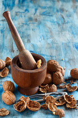 Fresh walnuts and mortar on a blue wooden table