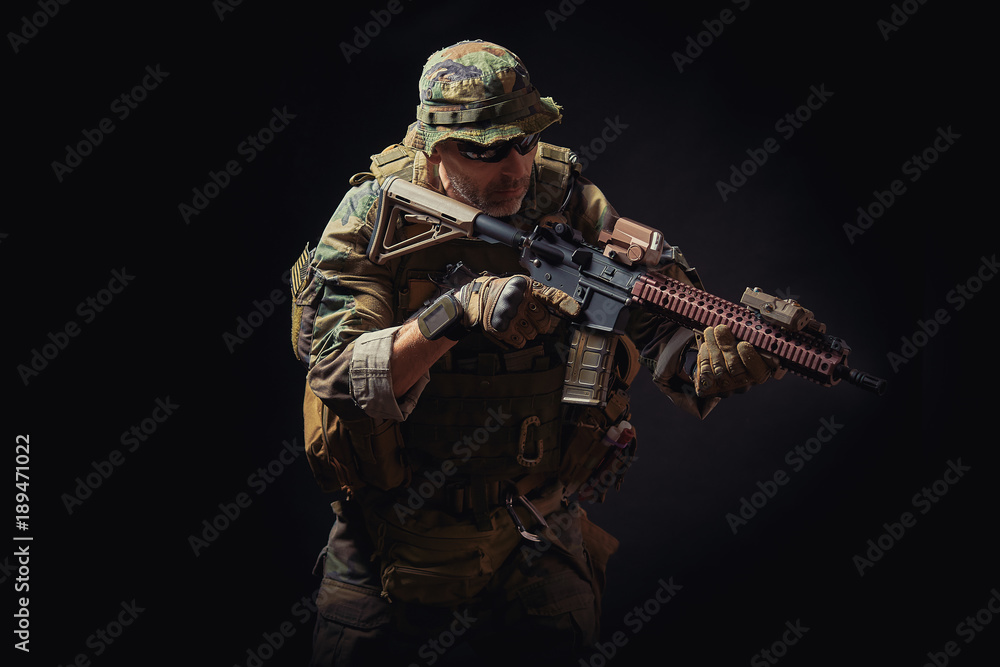 Wall mural special forces soldier of the united states poses with a rifle on a black background