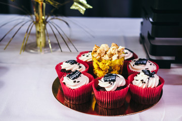 Tasty candy bar with popcorn and muffins in red, black and gold colors