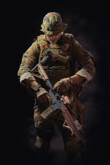 Fototapeta na wymiar special forces soldier of the united states poses with a rifle on a black background