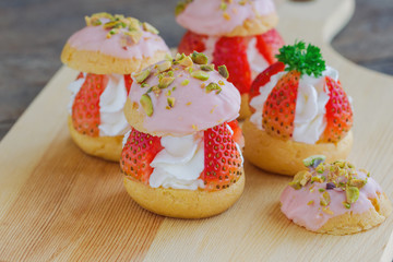 Strawberry choux cream. Combination with choux pastry whipped cream fresh strawberries glaze with white chocolate and chopped pistachios. Sweet and delicious dessert for Valentine. Homemade bakery.