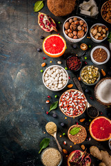 Set of organic healthy diet food, superfoods - beans, legumes, nuts, seeds, greens, fruit and vegetables. Dark blue background copy space top view