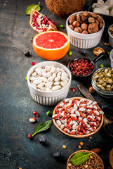 Set of organic healthy diet food, superfoods - beans, legumes, nuts, seeds, greens, fruit and vegetables. Dark blue background copy space top view