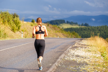 Jeune femme sportive jogging sur route de montagne. Fille de remise en forme en cours d& 39 exécution dans l& 39 image extérieure de vêtements de sport avec espace de copie