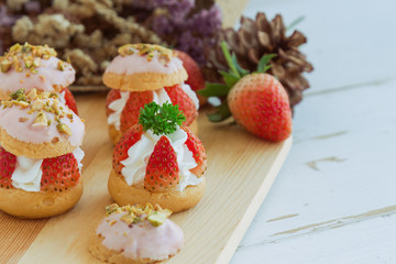 Strawberry choux cream. Combination with choux pastry whipped cream fresh strawberries glaze with white chocolate and chopped pistachios. Sweet and delicious dessert for Valentine. Homemade bakery.