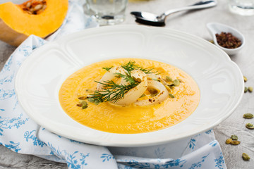 Homemade pumpkin and carrot soup with squid rings, seeds and dill © happy_lark