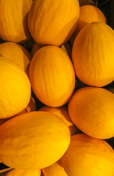 A whole box of fresh, yellow melons.