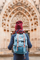 Fototapeta na wymiar rear view of a traveler woman with backpack looking at historical architecture, sightseeing tour concept