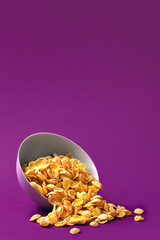 Bowl with cornflakes on the colorful background