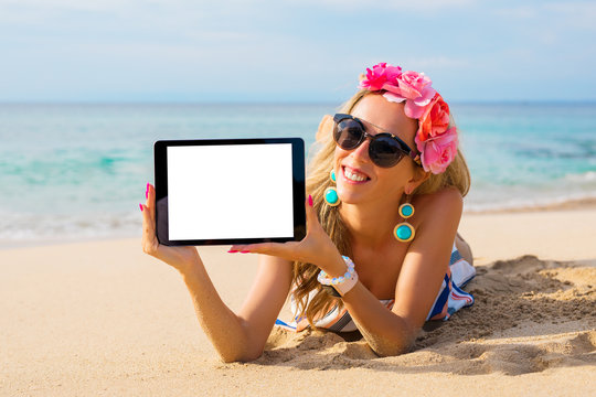 Hipster girl showing empty tablet on the beach, mockup for design.