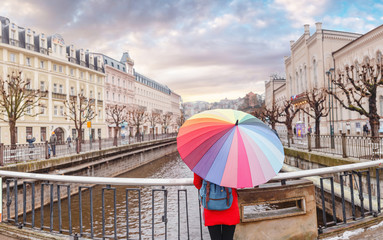 Cityscape view of hotels on a banks of Tepla river and woman tourist at winter