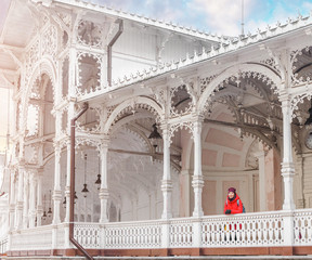 Woman tourist in red jacket at The Market Colonnade with its white structure in Karlovy Vary