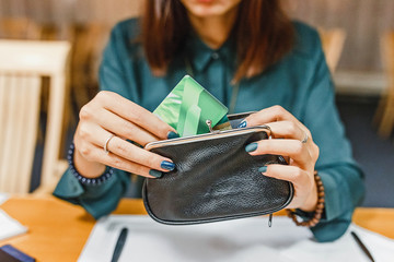 Woman takes the credit card out of wallet in restaurant