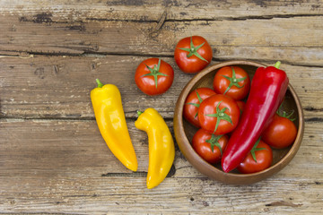 tomatoes and peppers on wooden background