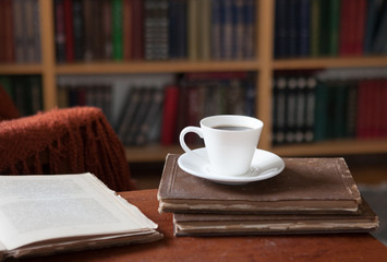Sweet moments of relaxation with books and a cup of coffee. Vintage books, glasses, chair, library