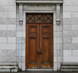 Fototapeta na wymiar old vintage closed wooden doors on grey stone wall building