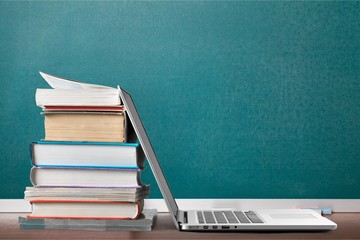 Stack of books with laptop