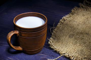 Milk in an earthen pit on a wooden background
