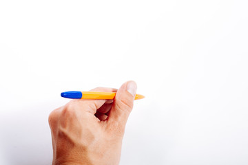 A man is holding a pen in his left hand on a white background.