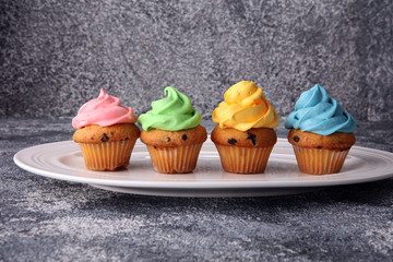 Tasty cupcakes on grey background. Birthday cupcake in rainbow colors