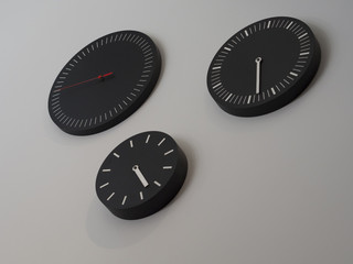 Three black clocks with time zone of different countries