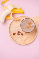 Fototapeta na wymiar Banana smoothie with banana, milk, almonds in glass glasses on a white table, top view, horizontal, selective focus
