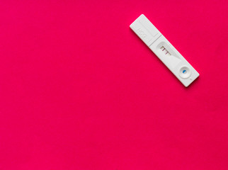 Pregnancy test with  pregnant result on red background.