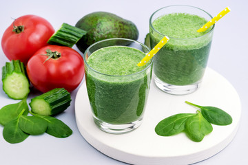 Fresh Tasty Spinach Cucumber Avocado Tomato Smoothie in Glasses Fresh Vgetables Detox Drink White Wooden Tray Gray Background Horizontal