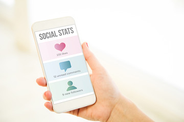Woman holding a pink gold blank smartphone social stats