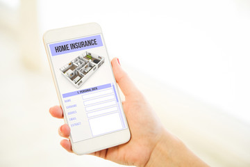 Woman holding a pink gold blank smartphone wshowing home insurance form