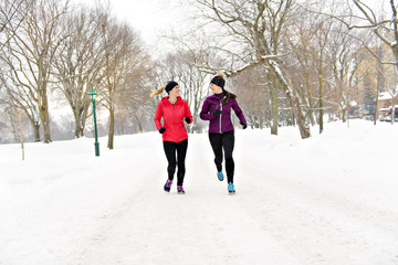 Group of friends enjoying jogging in the snow in winter